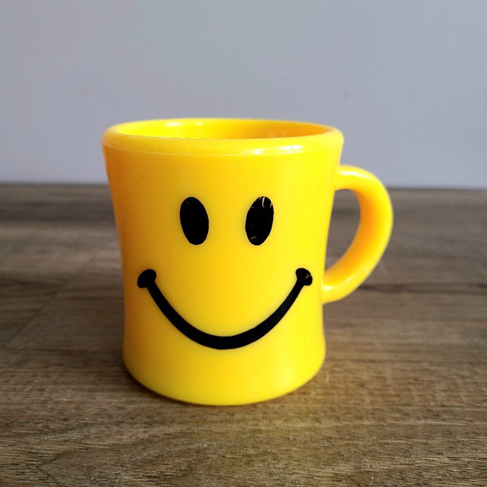 Vintage smiley face hand plastic yellow mug.